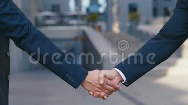 两位业务伙伴见面时握手.. 两位成功商人的握手结束了交易。 慢慢